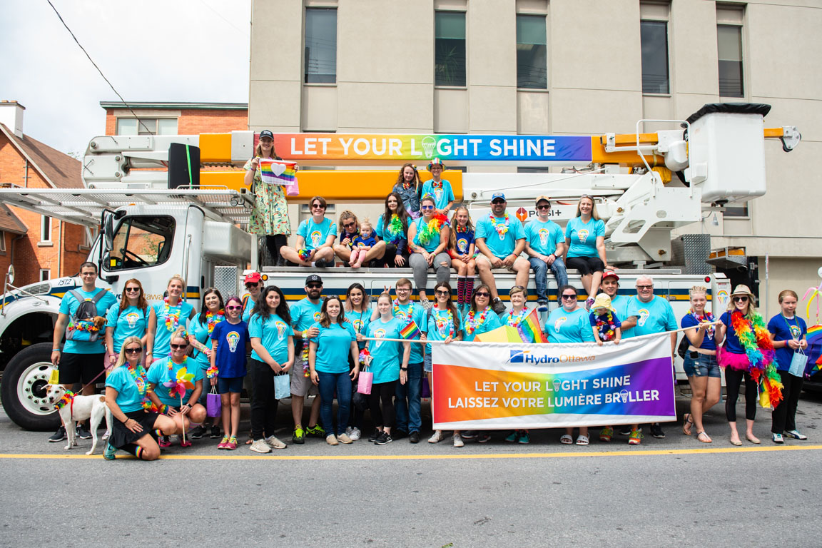 Hydro Ottawa employees volunteering at Capital Pride in front of Hydro Ottawa truck