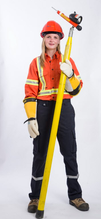 Powerline Technician, Lana Norton, stands wearing personal protective equipment