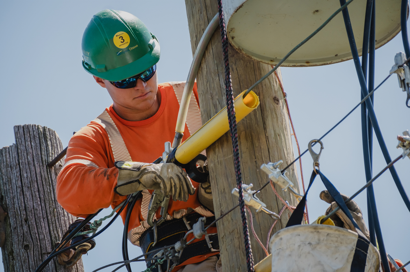 A young hydro worker makes repairs on a pole