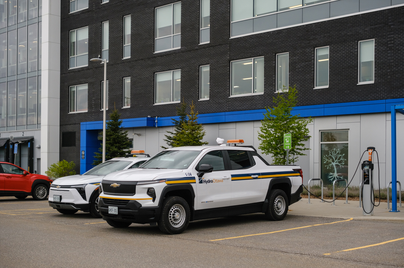 Hydro Ottawa electric fleet vehicles including a pick-up and car plugged into a charger
