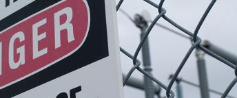 A warning sign on the surrounding fence of a Hydro Ottawa power station reads Danger. High Voltage.