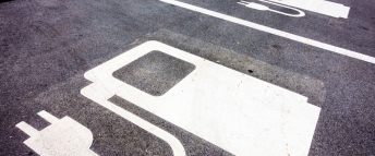 A series of parking spots with electric vehicle graphics painted on them
