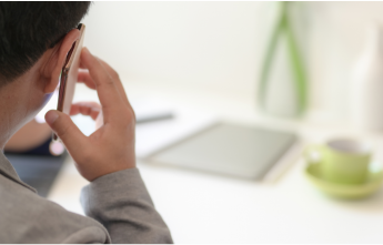 Man on cell phone in grey long-sleeve shirt