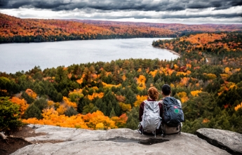 A young couple on a bluff overlooking Algonquin Park on a fall day