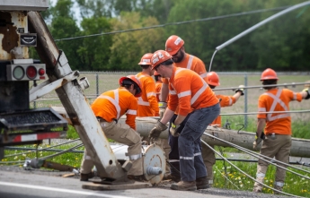 A team of hydro workers attempt to repair broken equipment next to a road