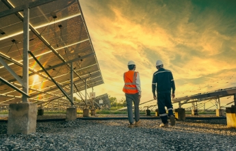 Engineers walk through a solar farm