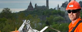 Powerline Maintainer working with Parliament Hill in the background