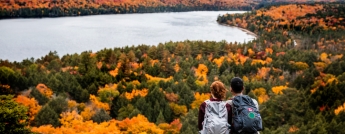 A young couple on a bluff overlooking Algonquin Park on a fall day