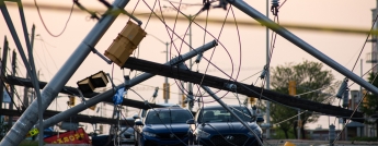 Hydro poles fallen across a street with vehicles