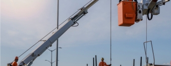 Hydro workers overseeing the arrival of new hydro poles