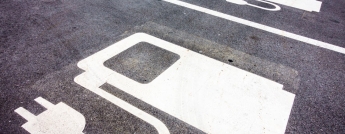 A series of parking spots with electric vehicle graphics painted on them