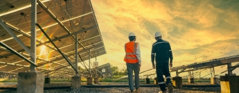 Engineers walk through a solar farm