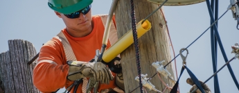 A young hydro worker makes repairs on a pole
